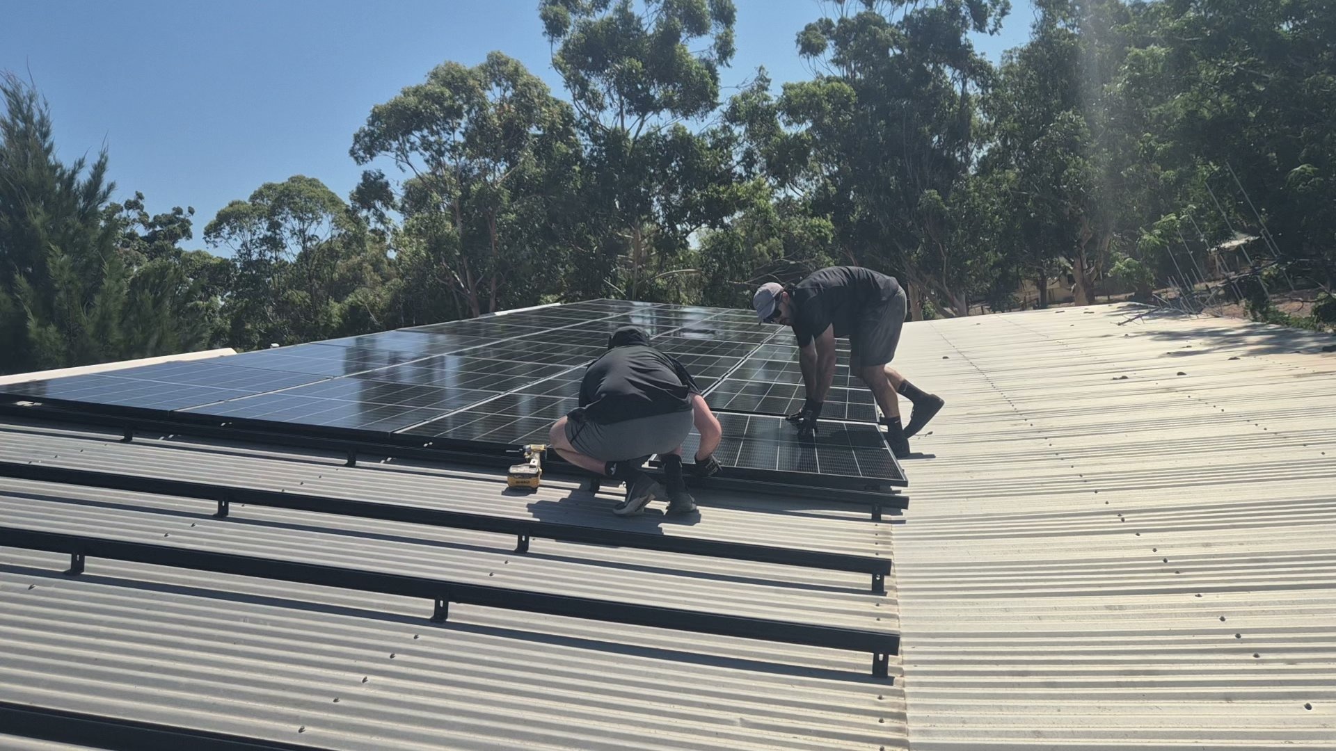 Two PSA installers working together on a Perth solar roof